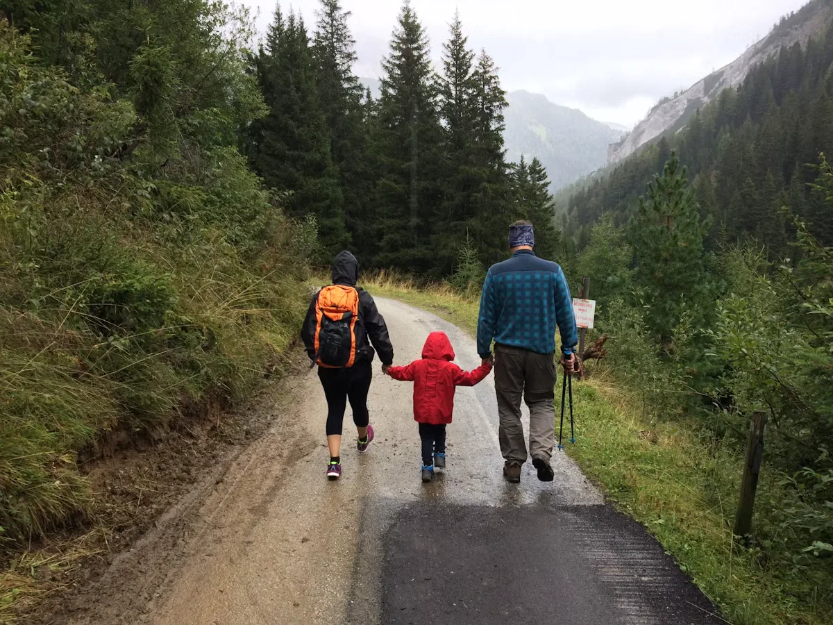 A man, woman, and child walking together along a quiet road