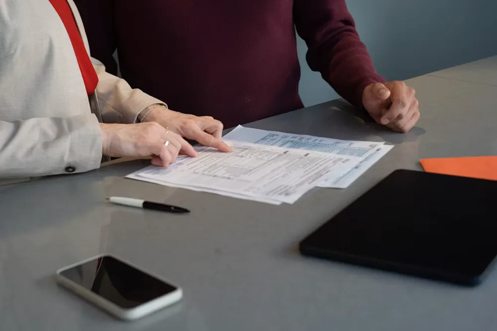 Two professionals reviewing paperwork together at a table